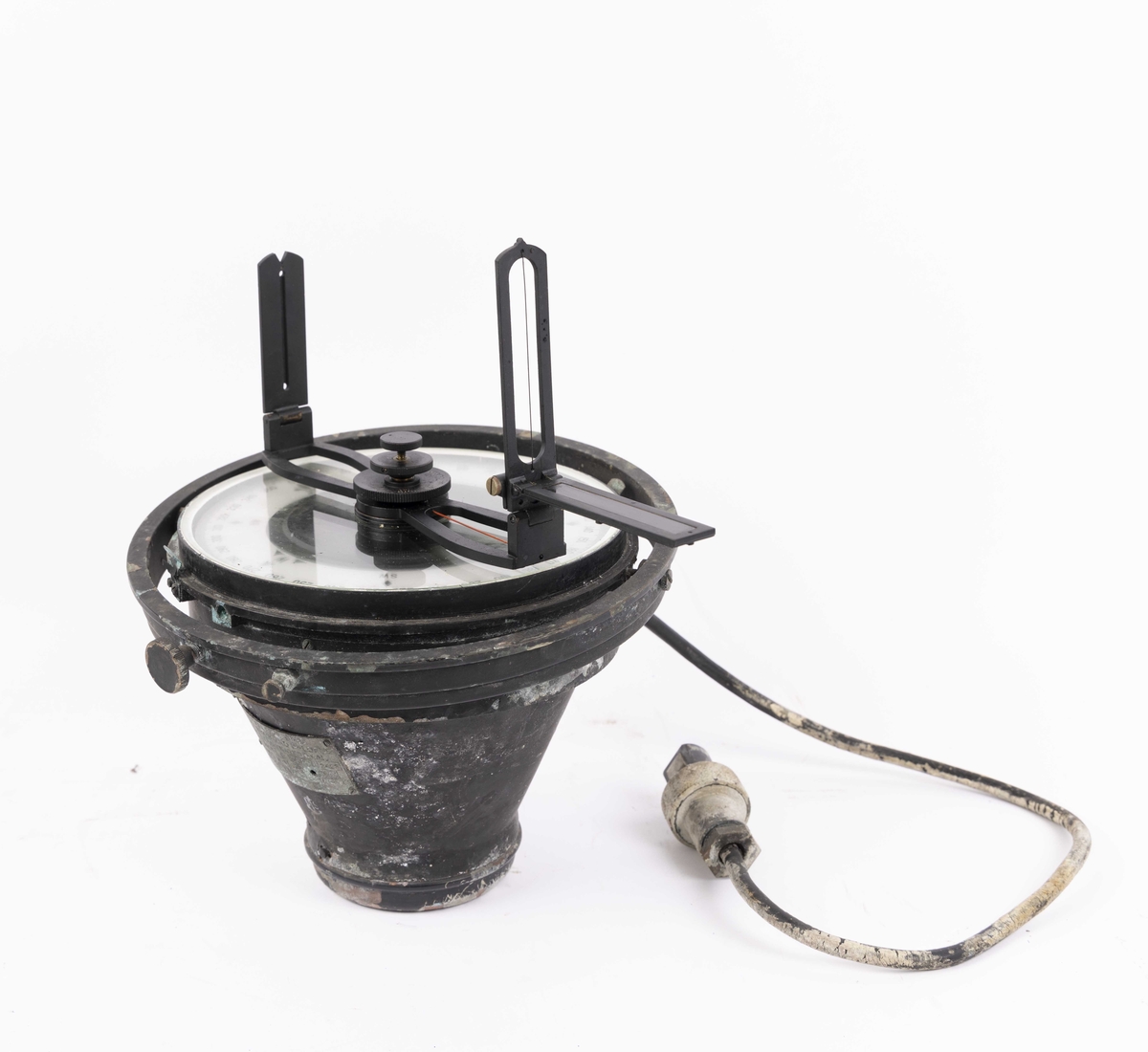 Gyrokompass med oppheng og siktedioptere, med elektrisk tilkobling og lys. Metallhette over kompasset. Oppbevart i egen transportkasse