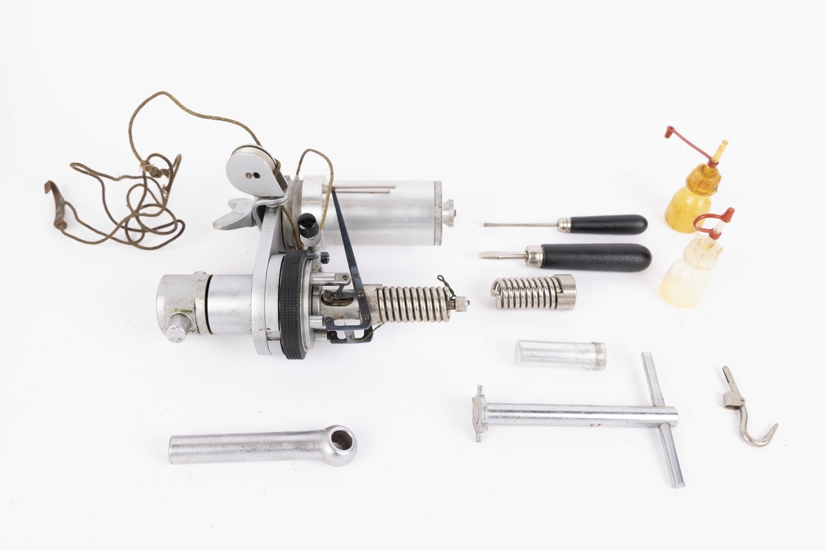 Indikator til måling av maskinhestekrefter. Dampmaskinindikator med flere deler i brun trekasse. Kassen har hengslet lokk og oppbevaringsrom for løse deler som oljeflasker, skrujern, krok, hefte med røde ark, nøkkel, linjal og andre deler. Med håndtak i skinn og lås med nøkkel.