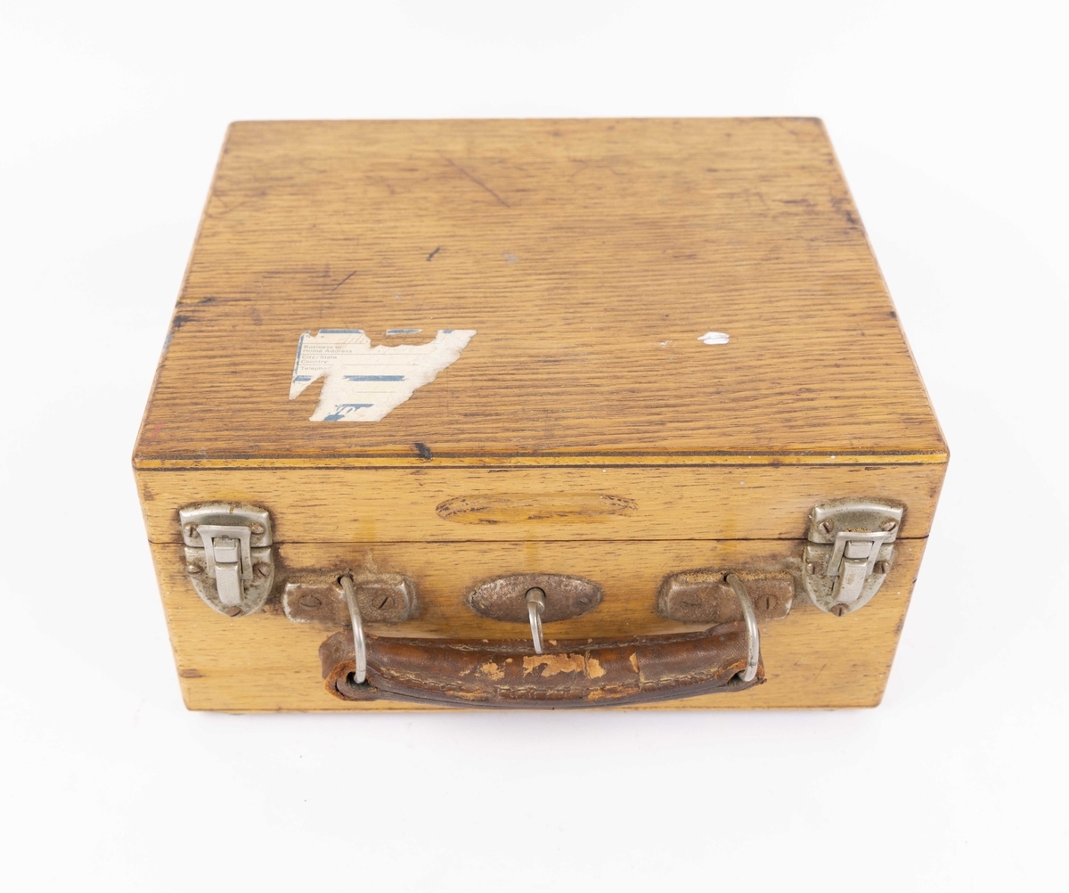 Indikator til måling av maskinhestekrefter. Dampmaskinindikator med flere deler i brun trekasse. Kassen har hengslet lokk og oppbevaringsrom for løse deler som oljeflasker, skrujern, krok, hefte med røde ark, nøkkel, linjal og andre deler. Med håndtak i skinn og lås med nøkkel.