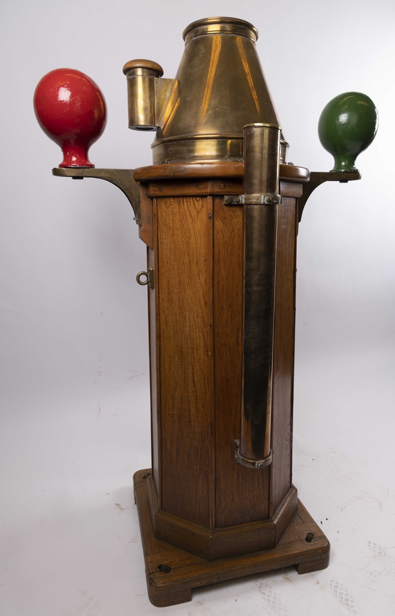 Natthus i tre og messing med kompass produsert av C. Plath. Med to kvadrantkuler, samt klargjort for tilkobling til elektrisk lys på høyre side. Med flinders stang montert bakpå sokkel. Har vært ombord i skip tilhørende J.L. Mowinckels Rederi. Klinometer i front mangler.