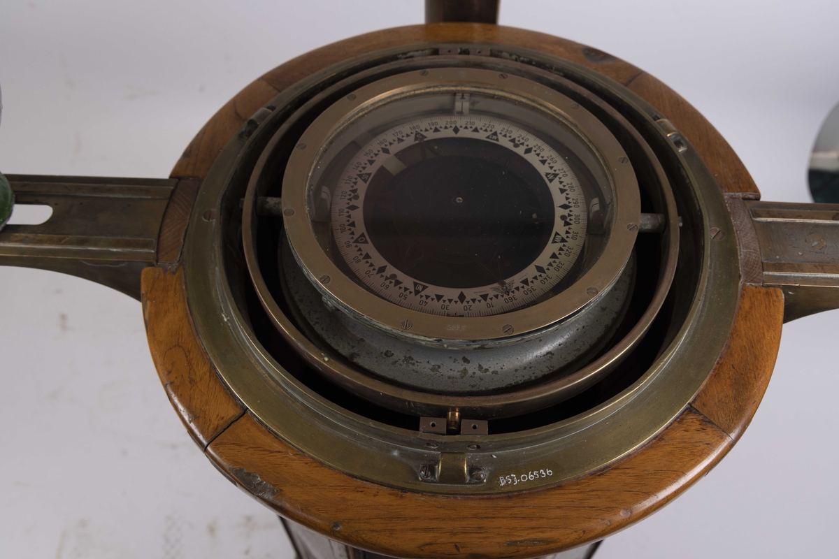 Natthus i tre og messing med kompass produsert av C. Plath. Med to kvadrantkuler, samt klargjort for tilkobling til elektrisk lys på høyre side. Med flinders stang montert bakpå sokkel. Har vært ombord i skip tilhørende J.L. Mowinckels Rederi. Klinometer i front mangler.