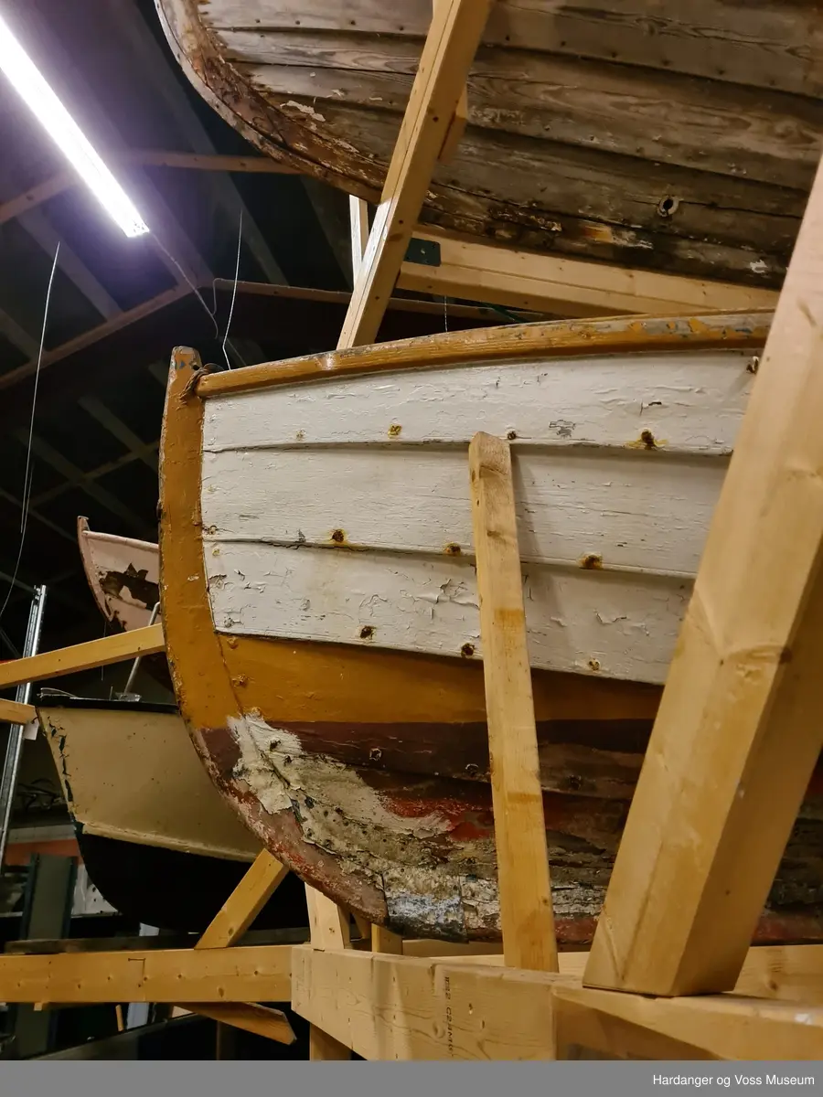 Lettbåt fra selfanger med to tofter i baugen med en lav vegg imellom, to par tollepinner på styrbord side, bredt sete i akter, samt ror med rorkult og en åragaffel festet til akterspeilet. Båten er hovedsakelig hvitmalt med okergule kanter og seter, blått ror, og den er rødmalt under bunnen. Båten er klinkbygget.