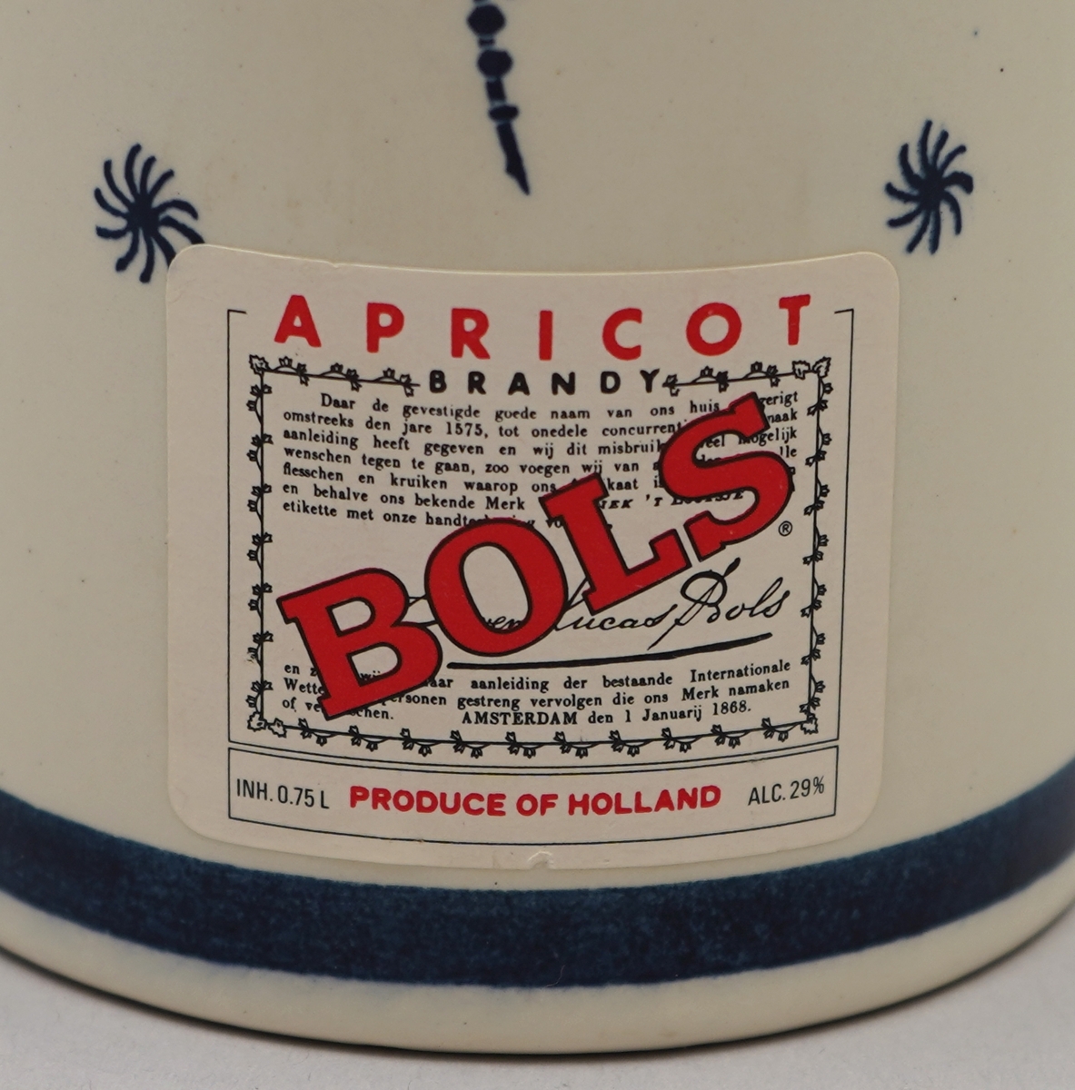 Kvit flaske med nederlandsk blå dekormåling. Pappkartong med nederlkandske folkelege motiv.