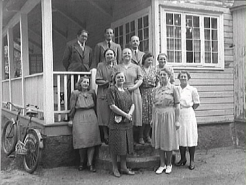 Guldsmed Albrektsson med familj och kanske ytterligare släkt eller vänner samlade på verandan till Tivedsstugan, Nya Påskberget.