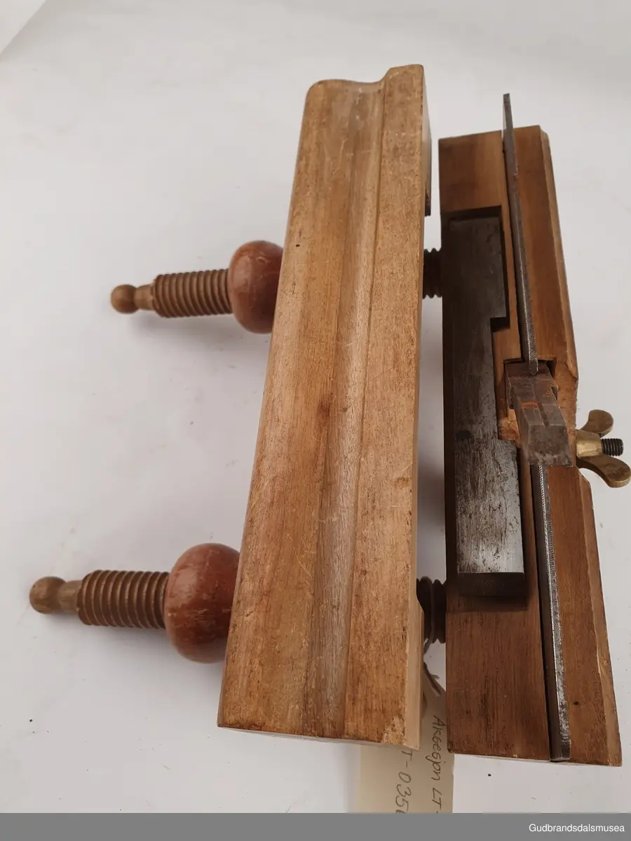 Ploghøvel, stillbar i høyde og bredde. Justeringsskruer i tre. 
Fabrikkprodusert; merket Joh-weiss.
Svimerket; J.m byggjordet, to ulike stempeltyper, 3 ulike plasser på høvelstokken.
Tilhørende 2 ekstra høvelstål. LT-03561, 01 og 02.