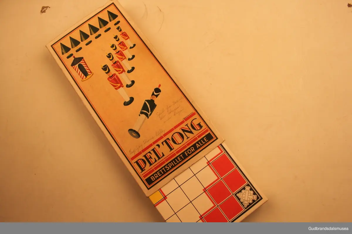 Brettspill fra ca 1940-1950 i orginaleske av papp. Spillet heter "Pel`tong", og går ut på å få fem egne brikker etterhverandre (5på rad).
Spillesken inneholder et spillebrett, som også danner esken sammenbrettet.Sammenbrettet stikkes dette inn i et fotreal av papp med logoen til spillet påtrykt. Det forhøyede spillbrettet har 20 små rom, til 10 røde spillbrikker og 10 grønne spillbrikker. Spillbrikkene er 4cm høye, dreid i tre, og skal ifølge trykk på fremsiden av esken forestille soldater. Et slags krigsspill. Eget lite hefte med spilleregler ligger i esken.
Usikker på produsent, men står merket" Kvalitetsmerke Sertifikat for spill og leker" og "Patent anm. mønster- besk." på esken.