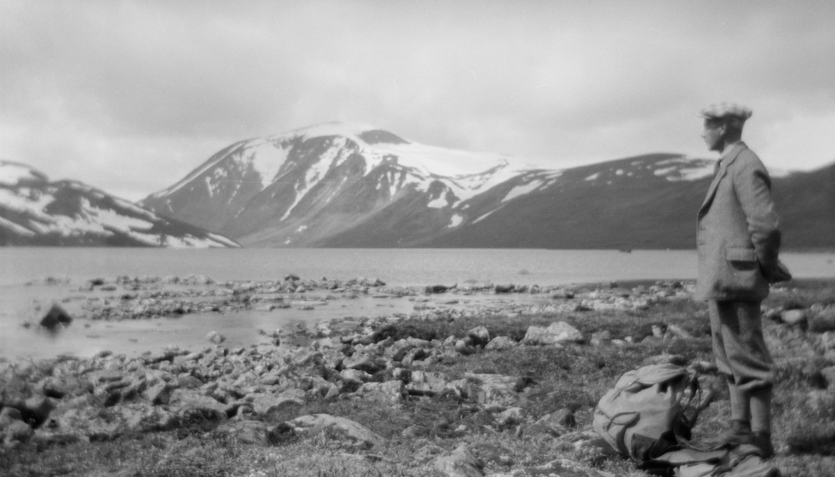 Mann som står og ser utover Bessvatnet med Besshø i bakgrunnen