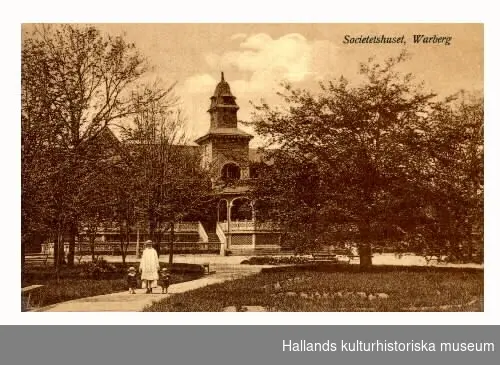 Vykort, "Societetshuset, Warberg". I förgrunden går en kvinna med två små barn i Societetsparken.