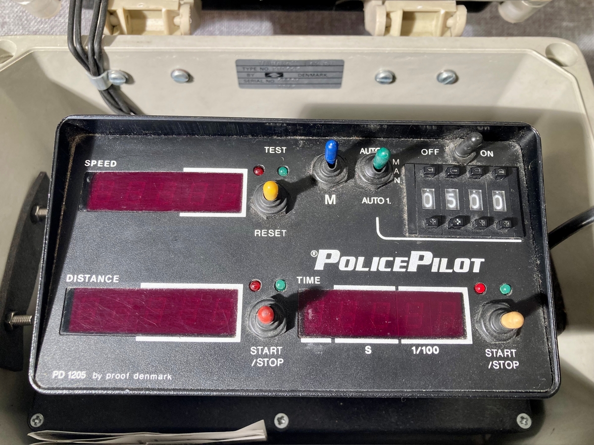 Bærbar politiradio i oppbevaringskasse med bærestropp.