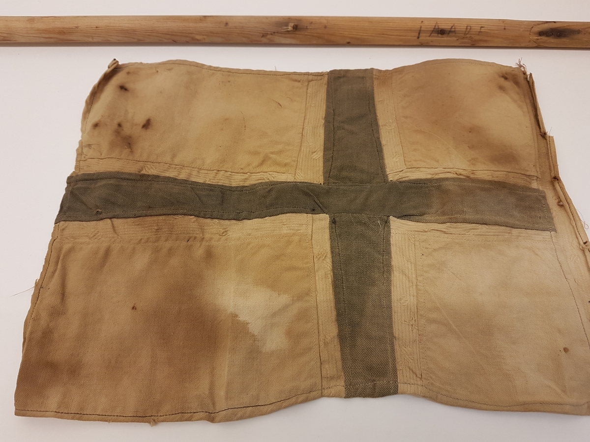 Hjemmesydd flagg som har vært festet til trestang. Flagget har tilhørt Ingeborg Anna Andersdatter Feragen (1916-1942). Ingeborg Anna var fra gården Jælet i Feragen. Hun frøs i hjel i snøstorm i Rödfjellet på svensk side 15. november 1942 da hun hjalp to flykninger over Vigelsfjella til Sverige, og ble gravlagt på kirkegården i Funäsdalen. Ingeborg Anna var ugift, men hadde en sønn. 

Ingeborg Anna er hedret på minnesmerket over fire personer fra Røros som mista livet i 2. verdenskrig ved krigsrelaterte handlinger, som henger på syd-veggen av Røros kirke.

Flagget er sterkt misfarget/falmet.