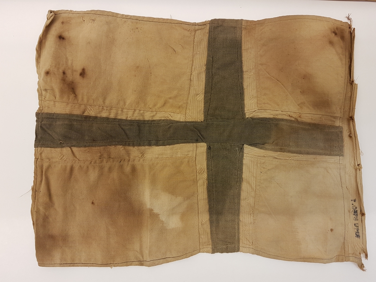 Hjemmesydd flagg som har vært festet til trestang. Flagget har tilhørt Ingeborg Anna Andersdatter Feragen (1916-1942). Ingeborg Anna var fra gården Jælet i Feragen. Hun frøs i hjel i snøstorm i Rödfjellet på svensk side 15. november 1942 da hun hjalp to flykninger over Vigelsfjella til Sverige, og ble gravlagt på kirkegården i Funäsdalen. Ingeborg Anna var ugift, men hadde en sønn. 

Ingeborg Anna er hedret på minnesmerket over fire personer fra Røros som mista livet i 2. verdenskrig ved krigsrelaterte handlinger, som henger på syd-veggen av Røros kirke.

Flagget er sterkt misfarget/falmet.