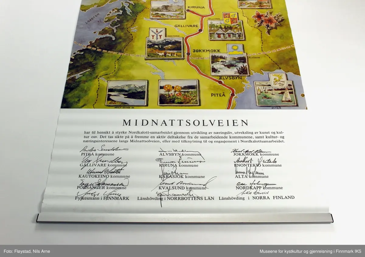 En plakat (rollup) uten etui. Plakaten er laget i forbindelse med avdukingen av Midnattsolveien monumentet. 

Øverst på plakaten er det trykt et lite bilde av Midnattsolmonumentet og tittel "Midnattsolmonumentet avduket 7. juni1984".

Rett under tittelen er det trykkt et stort kartbilde over midnattsolveien med bilder av fra de stedene veien går gjennom. Øverst i venstre hjørne er det trykt et bilde med motiv av Nordkapplatået i midnattsol under er det et kartbilde over hele vest- Europa med logoen til Midnattsolveien nede i høyre hjørne. 

Nederst på plakaten er det trykt en tekst om prosjektet Midnattsolveien og siganturer til alle som har deltatt i samarbeidet.