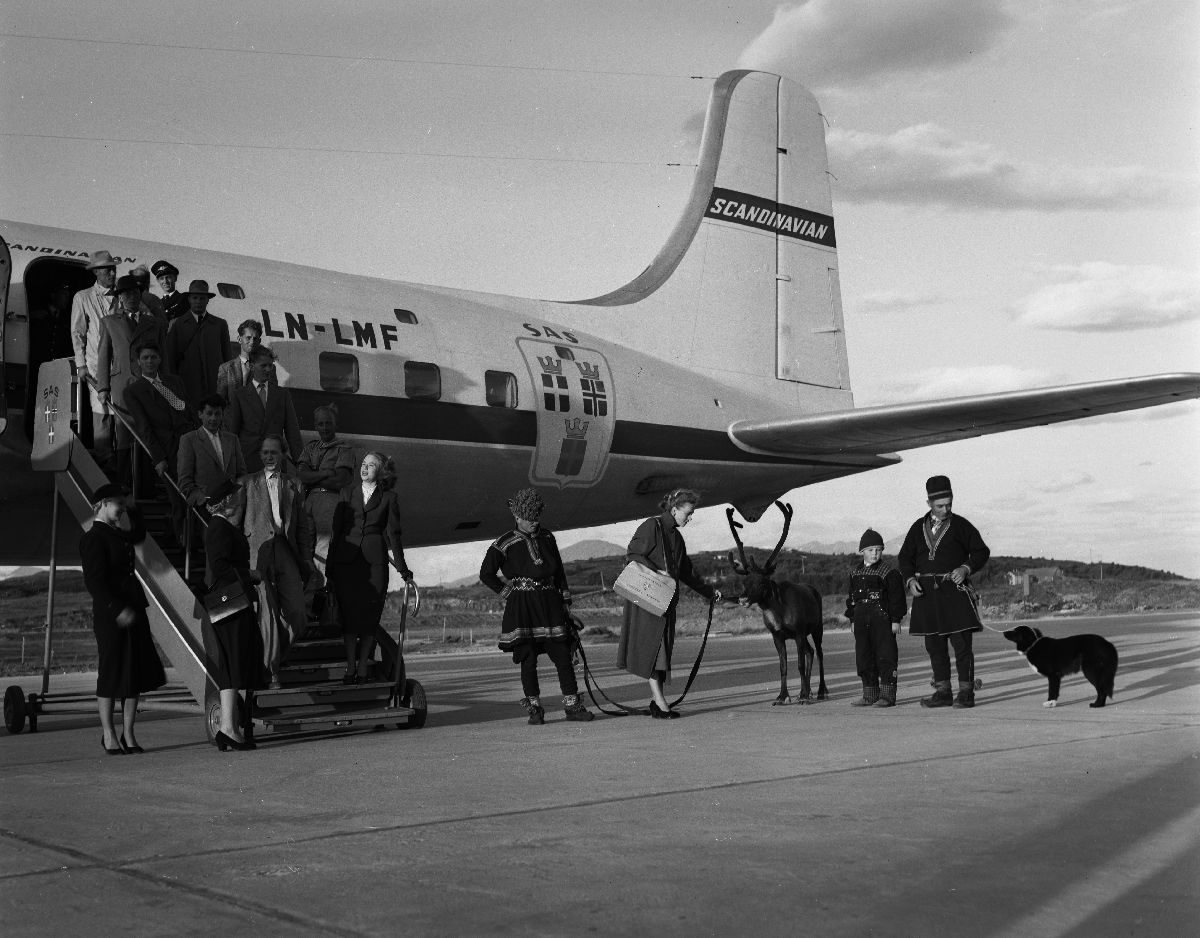 Flypassasjerer ble møtt av familien Karlstad, hunden Dilko, et reinsdyr og turistforeningens guide, da de ankom Bodø flyplass med SAS’ «Midnattssol-ruta». Flyet «Agne Viking» var en DC-6B med registreringsnummer LN-LMF.