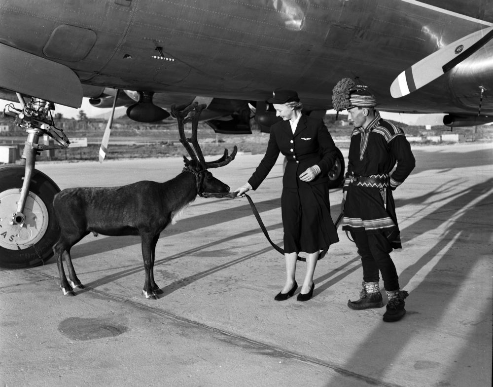 Kalle Karlstad og en flyvertinne står oppstilt ved SAS' DC-6B "Agne Viking".