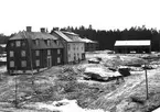 Jungfru Lovisas gård och Spegelmakaregården. Båda husen är flyttade från Ågatan i Linköping. Fotografiet är taget vintern 1954-55. 
Dateringen är baserad på att i september 1954 var det fortfarande ställningar runt Jungfru Lovisas och våren 1955 påbörjades uppsättning av Sundbergska längan, där presenningshögen är.
 ...

385 bilder om Linköping på 1950-talet från tidningen Östgötens arkiv. Framtidstro och optimism är ord som sammanfattar Linköping på femtiotalet. Årtiondet innebar satsningar för att förbättra linköpingsbornas livsvillkor. Bostadsfrågan och trafiklösningarna dominerade den lokalpolitiska agendan.
Bilderna digitaliserades år 2013.