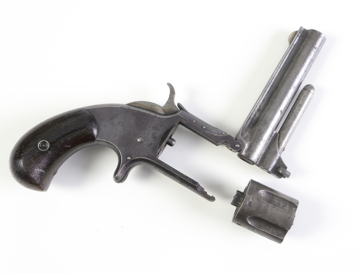 Revolver, Smith & Wesson, med trumma kamrad för fem patroner och räfflad pipa. Revolvern är enkelverkande, d.v.s. man måste spänna hanen manuellt innan skott kan avlossas. Plunderstock finns fast monterad under pipan, något som gör att man måste fälla upp pipan genom att lossa en spärr strax under trummans främre del, s.k. tip-up model. Därefter kan man, efter borttagande av trumman, trycka ut tomhylsorna. Sidoblecket är blånerat, och revolvern har en rundad kolv med kolvplattor av trä. Riktmedlen är fasta.
Inskrivet i huvudkatalogen 1971.