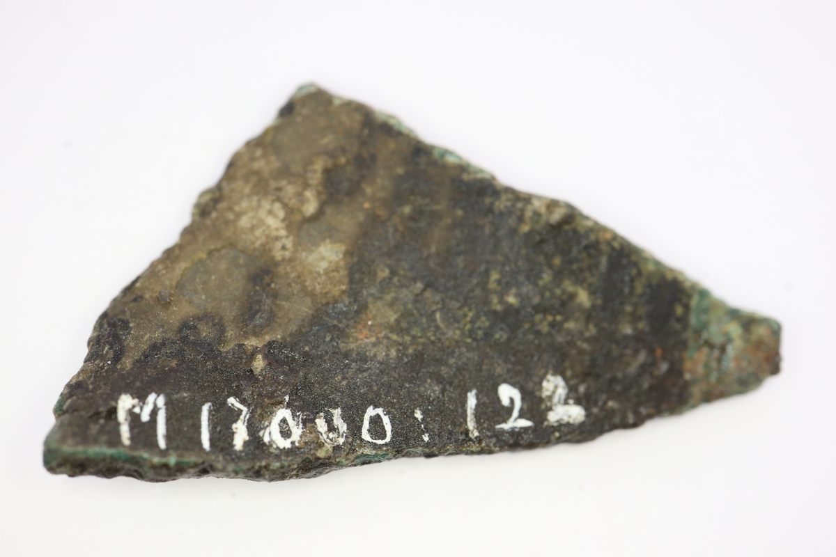 Brandskadat fragment av bronsgryta.  Bukbit.