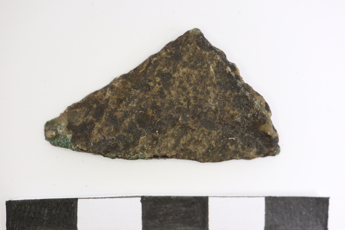 Brandskadat fragment av bronsgryta.  Bukbit.
