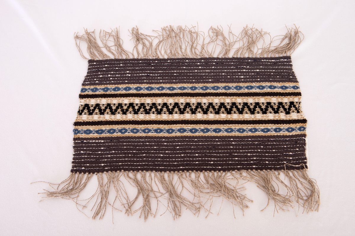 Provet har en maskinskriven papperslapp med texten: Nr 48, 3. Bollnäs Hemslöjdsförening. Prov vävt av  Bricken Gyllenhammar. Gåva av Elsa och Karin Nordenfelt.