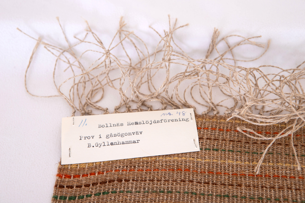 Provet har en maskinskriven papperslapp med texten: Nr 48, 11. Bollnäs Hemslöjdsförening. Prov i gåsögon väv. B. Gyllenhammar.