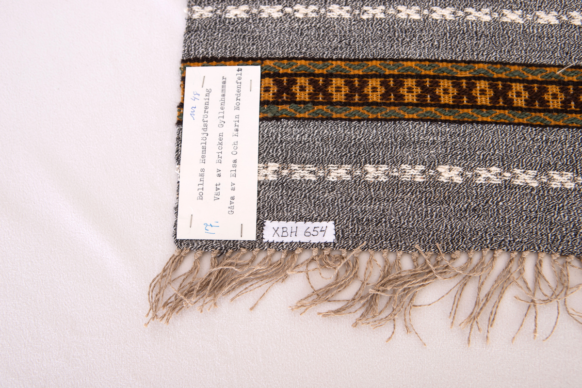 Provet har en maskinskriven papperslapp med texten: Nr 48, 17.Bollnäs Hemslöjdsförening.  Vävt av Bricken  Gyllenhammar. Gåva av Elsa och Karin Nordenfelt.
