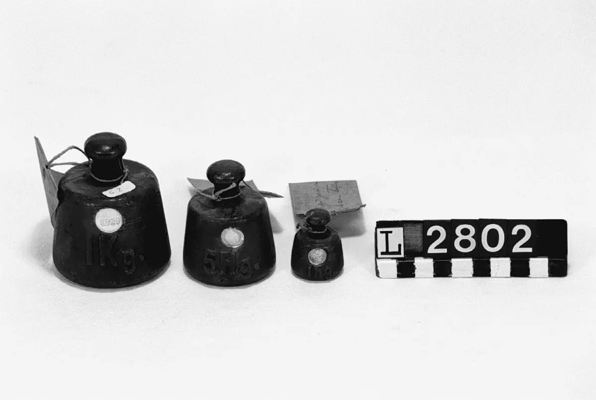 Tre st. 1 kg krönt 11 29. 5 hg krönt 11 30. 1 hg krönt 11 30. Cylindriska något koniska med knoppar. Samtliga försedda med adresslappar med text: Inköpt prov av Husquarna tillv. 
Höjd: 36-77 mm, diameter: 29-63 mm.