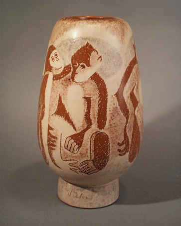 Av lergods med ett lager vitlera med agraffitodekor i form av apor. Stämplad: Ekeby 352 V.L. På foten inristad i vitleran: Vicke=Vicke Lindstrand 1947.