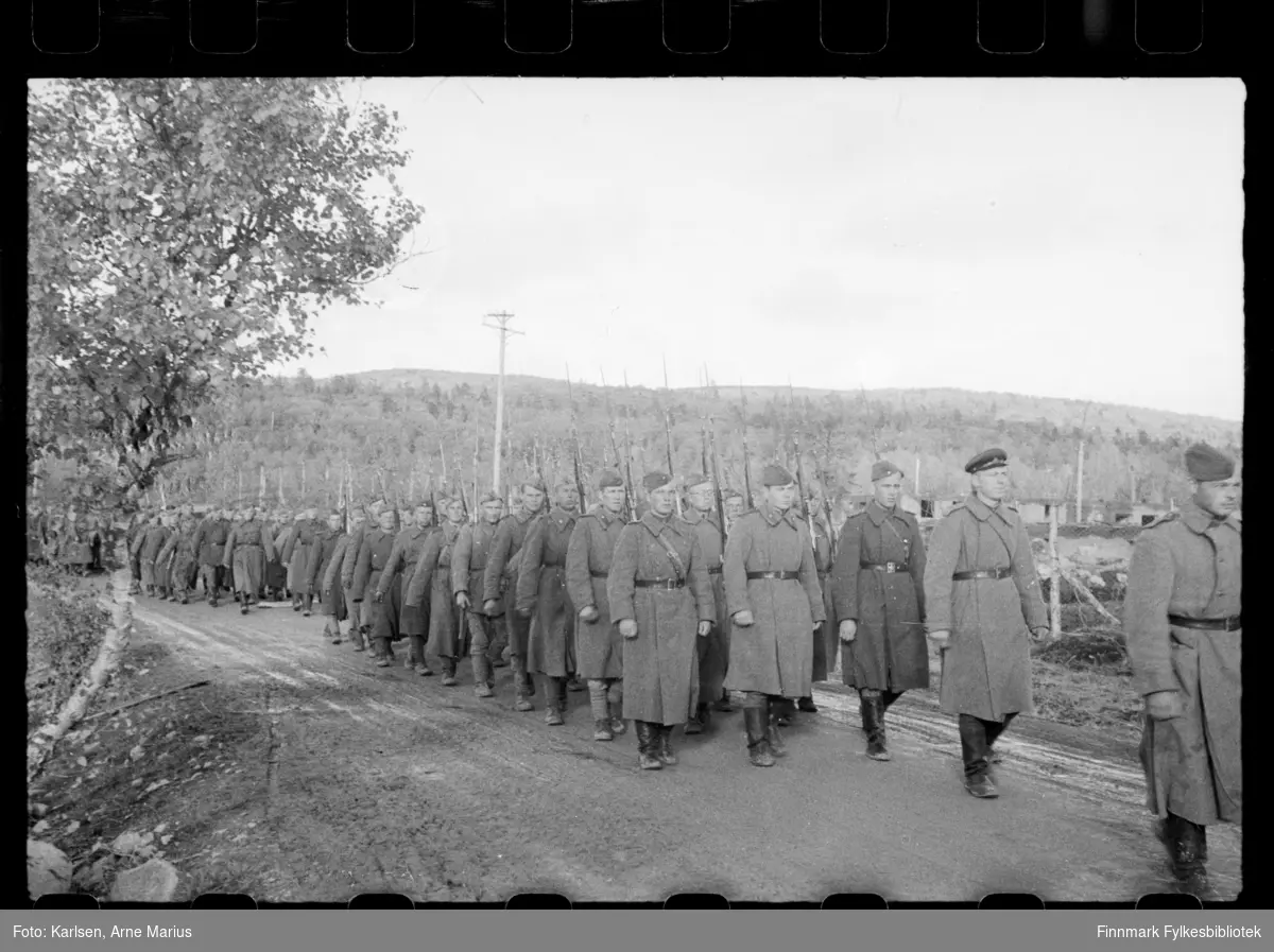 Russiske soldater marsjerer nær på grensa i Sør-Varanger ved grensebom i Storskog. I følge notat tilhørende bildene var bildene tatt av en russisk fotograf 
