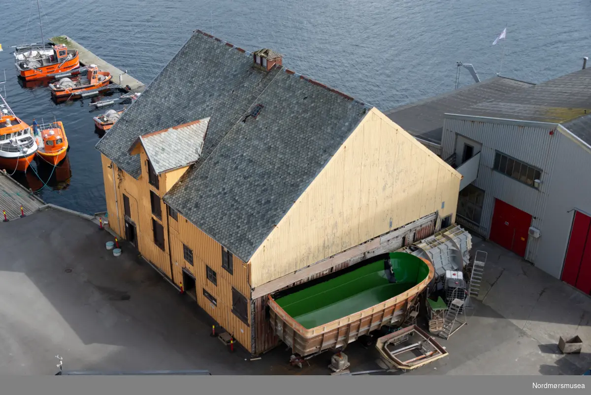 Volckmarbrygga. SEFRAK NR. 1503-01-36. Sørholmveien 15 på Kirklandet i Kristiansund. Lengde: 20,2 meter og Bredde: 18,6 meter. Oppført før 1885 i 3 etasjer + 2 loftsetasjer. Byggherre var Nicolay Volckmar som også eide bryggen i en lengre periode. Opprinnelig brukt som klippfiskbrygge. I nyere tid brukt til lager, motorverksted og snekkerverksted. Fundamentet til brygga var pilarer av naturstein på tømra kar. Konstruksjon og kledning var i laftet plank, trepanel, eternitt og bølgeblikk. Taktekking i hogd skifer. Fotografert 12. april 2016. Bryggen ble like etter revet.