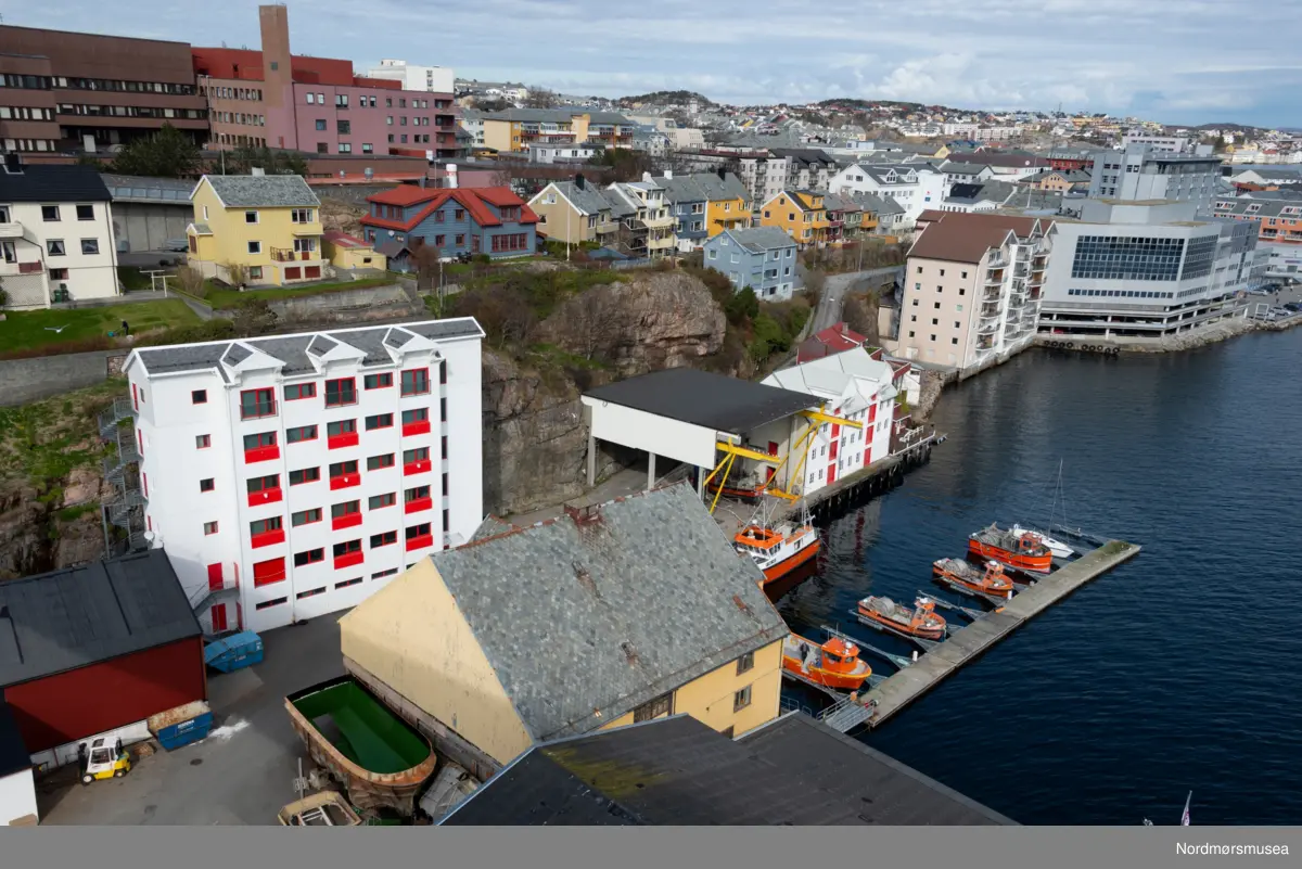 Volckmarbrygga. SEFRAK NR. 1503-01-36. Sørholmveien 15 på Kirklandet i Kristiansund. Lengde: 20,2 meter og Bredde: 18,6 meter. Oppført før 1885 i 3 etasjer + 2 loftsetasjer. Byggherre var Nicolay Volckmar som også eide bryggen i en lengre periode. Opprinnelig brukt som klippfiskbrygge. I nyere tid brukt til lager, motorverksted og snekkerverksted. Fundamentet til brygga var pilarer av naturstein på tømra kar. Konstruksjon og kledning var i laftet plank, trepanel, eternitt og bølgeblikk. Taktekking i hogd skifer. Fotografert 12. april 2016. Bryggen ble like etter revet.