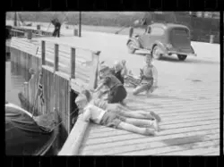 Barn fisker på kai i Kirkenes. En av guttene holder en line 
