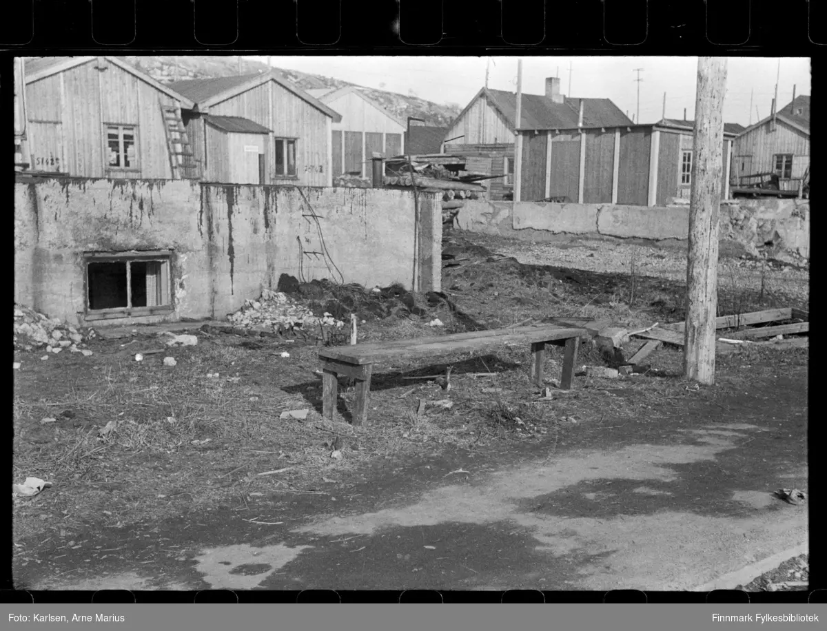 Foto av gateparti i Kirkenes, antagelig tatt på slutten av 1940-tallet, tidlig 1950-tallet i Kirkenes

I bakgrunnen kan man se diverse bygg og grunnmurer