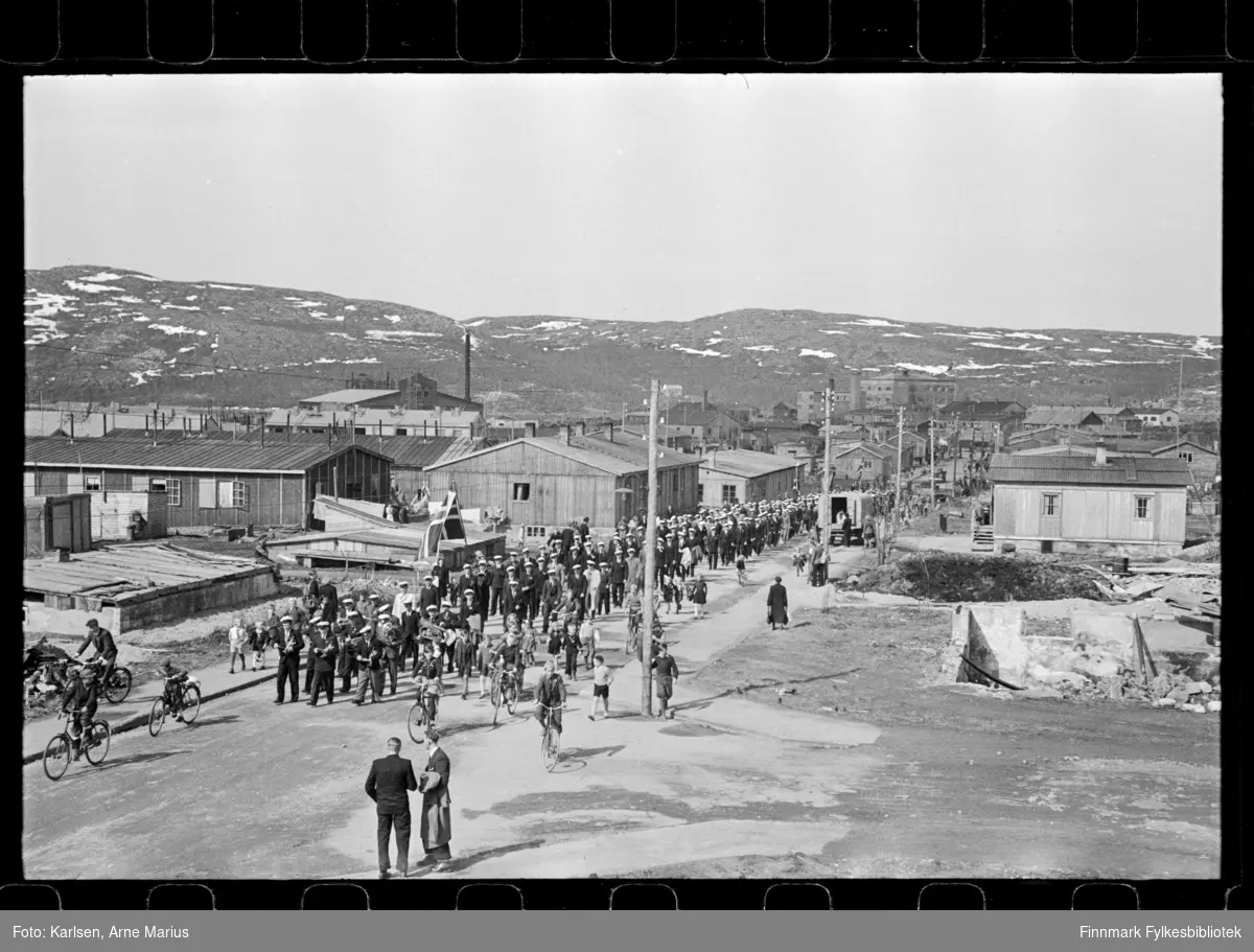I pinsen (25-26.mai) 1947 ble det avholdt sangerstevne i Kirkenes, der folk kom med huritgruten fra Båtsfjord, Vardø, Vadsø og Honningsvåg. Foto antagelig tatt i denne anledning

Mannskor marsjerer i parade. Framst i paraden kan man se et korps. I bakgrunnen kan man se deler av Dampsentralen (til venstre)