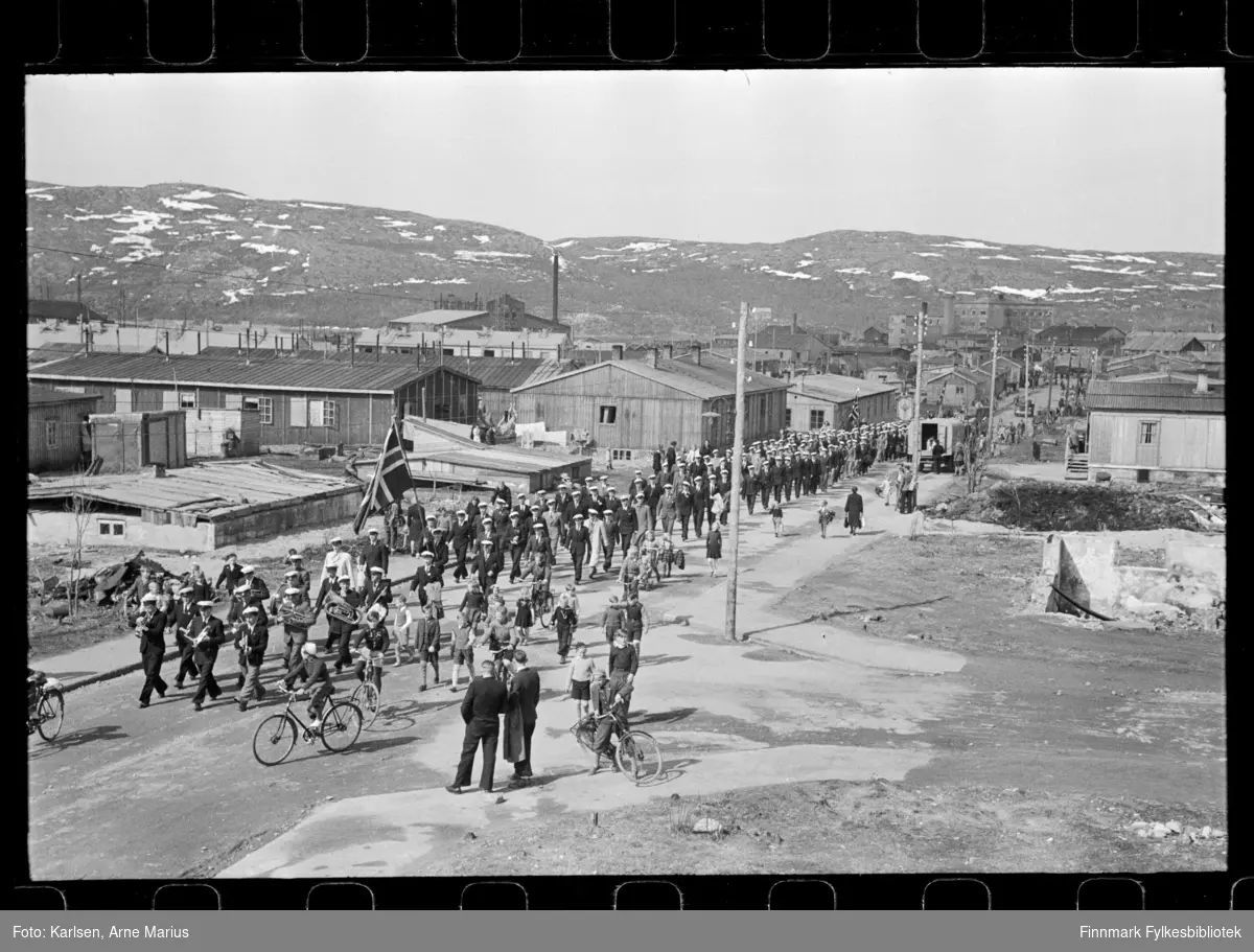 I pinsen (25-26.mai) 1947 ble det avholdt sangerstevne i Kirkenes, der folk kom med huritgruten fra Båtsfjord, Vardø, Vadsø og Honningsvåg. Foto antagelig tatt i denne anledning

Mannskor marsjerer i opptog. Framst i toget kan man se et korps. I bakgrunnen kan man se deler av Dampsentralen (til venstre)
