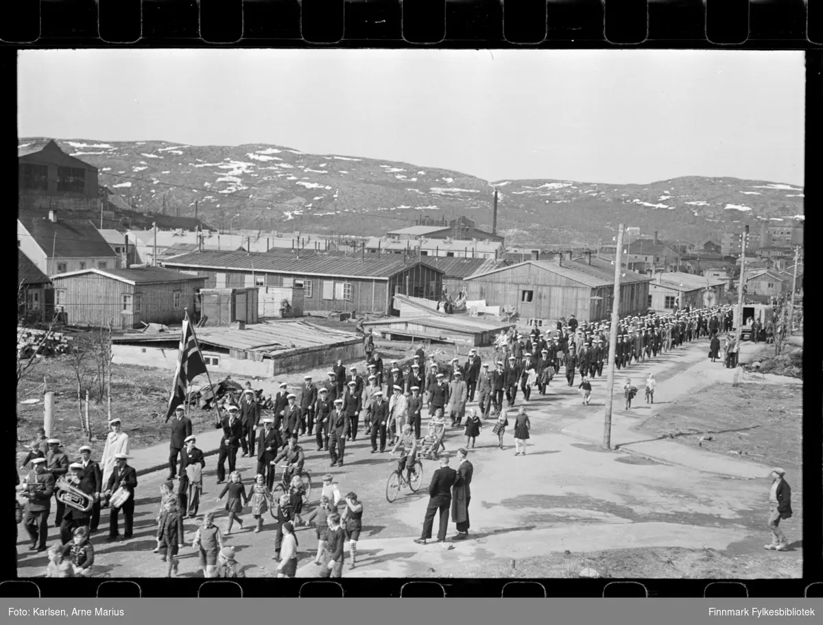 I pinsen (25-26.mai) 1947 ble det avholdt sangerstevne i Kirkenes, der folk kom med huritgruten fra Båtsfjord, Vardø, Vadsø og Honningsvåg. Foto antagelig tatt i denne anledning

Mannskor marsjerer i opptog. Framst i toget kan man se et korps. I bakgrunnen kan man se deler av Dampsentralen (til venstre)