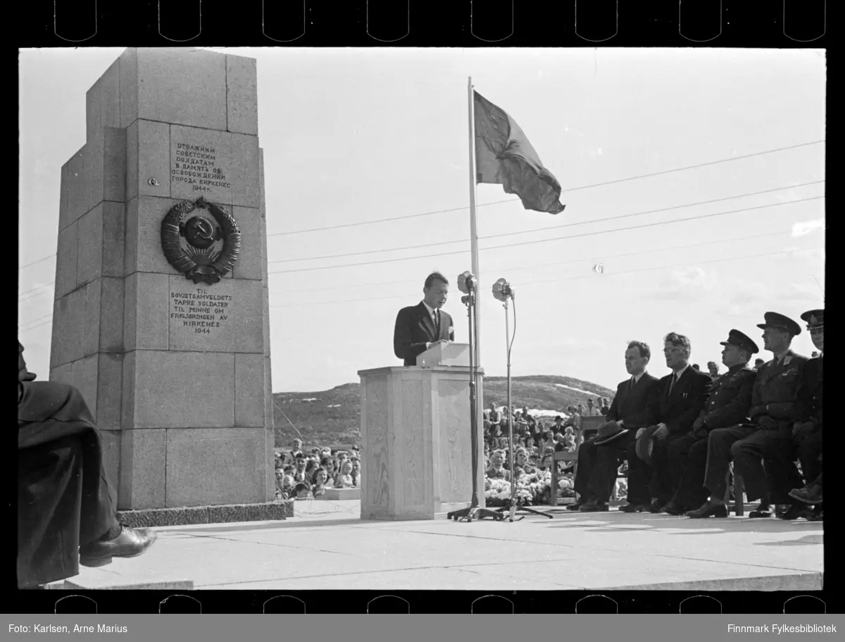 Avduking av Frigjøringsmonumentet (Russemonumentet) i Kirkenes den 8. juni 1952

Til avdukninga ved Haganeshaugen kom blant andre fiskeriminister Peder Holt og representanter fra sovjets ambassade. Peder Holt sitter som nr. 2 fra venstre. Muligens den russiske diplomaten F. A. Michailov i talerstolen, usikker identifisering 