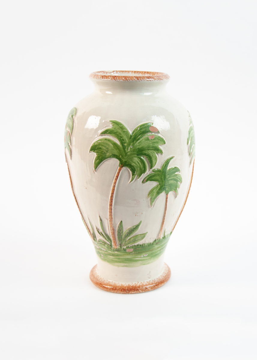 Dreid urneformet vase på fotring. Gul bunnglasur med brun kant. Palmemotiv i relieff i brun og grønt.