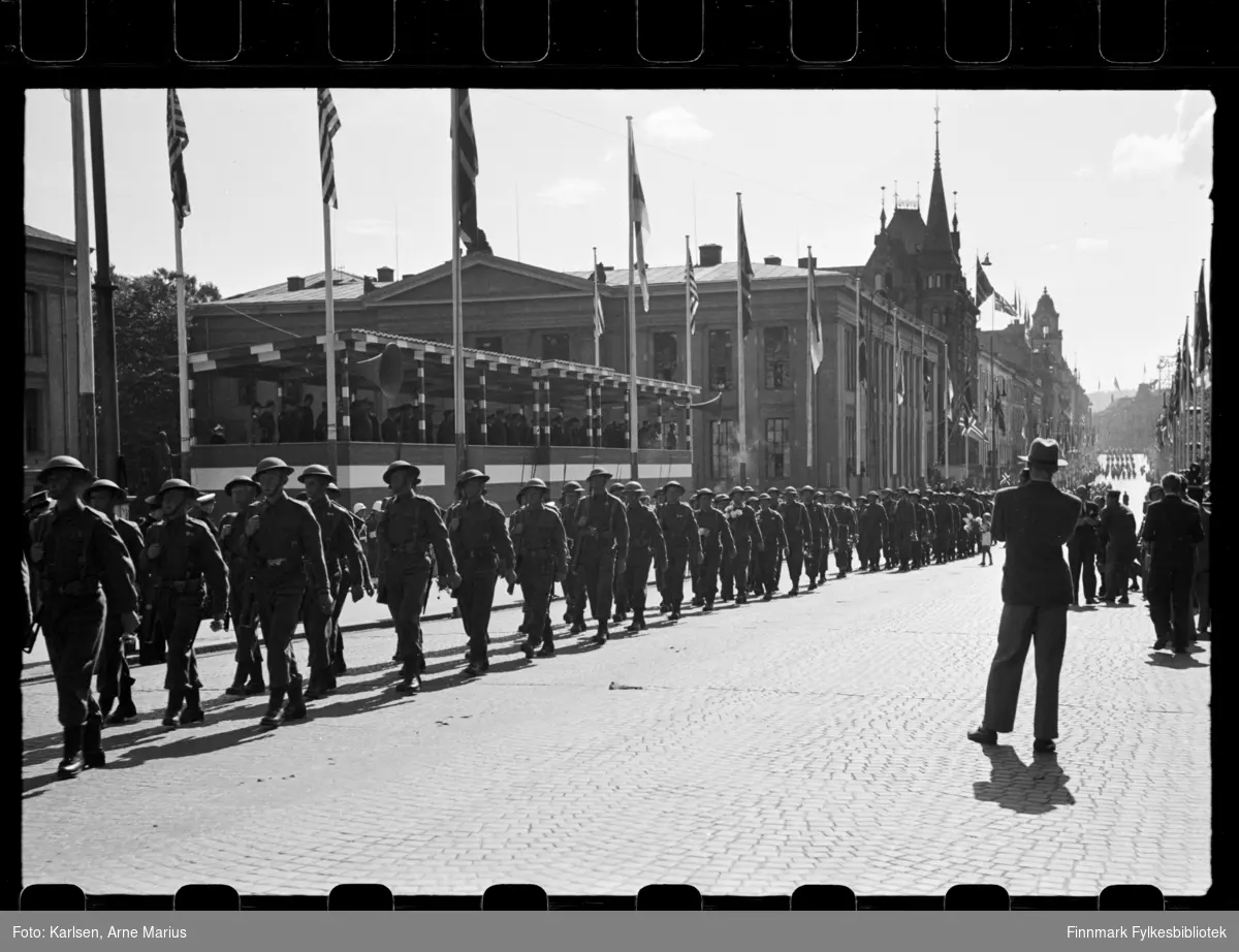 Britiske soldater marsjerer i parade på de alliertes dag den 30. juni 1945 (The Allied Forces day)

I bakgrunnen kan man se en tribune med flere offiserer som tilskuere