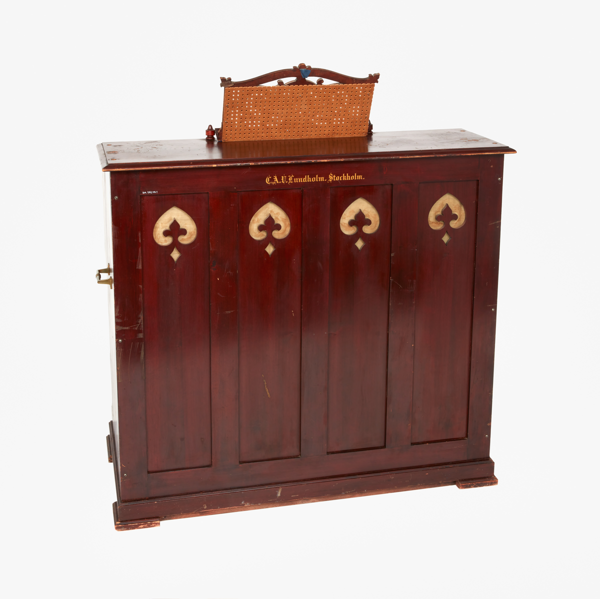 Rödbetsat orgelharmonium med notställ. Toppskiva med spår av gavelornament som idag saknas. Fyra oktaver och åtta registerandrag. Märkt "C.A.V Lundholm, Stockholm". Backstycke i trä med ventilhål. Sidor med handtag i mässing.
Har tillhört pastor Andrén, Falu Kristine församling.