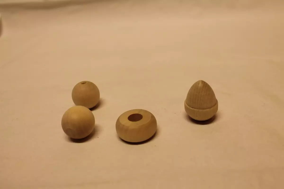 4 ulike knotter:
1. Flat knott, med bora hull på 1 cm i diameter. Ubehandla tre. Ubrukt. 3,4 cm i diameter. 
2. Rund knott med bora hull på 0,5 cm i diameter. Ubehandla tre. Ubrukt. 2,9 cm i diameter
3. Rund knott med bora hull på 0,5 cm i diameter. Ubehandla tre. Ubrukt. 2,9 cm i diameter
4. Konisk forma knott, med dreid bord på midten. Lengde 3,7 cm. Diameter med bord 3 cm. 