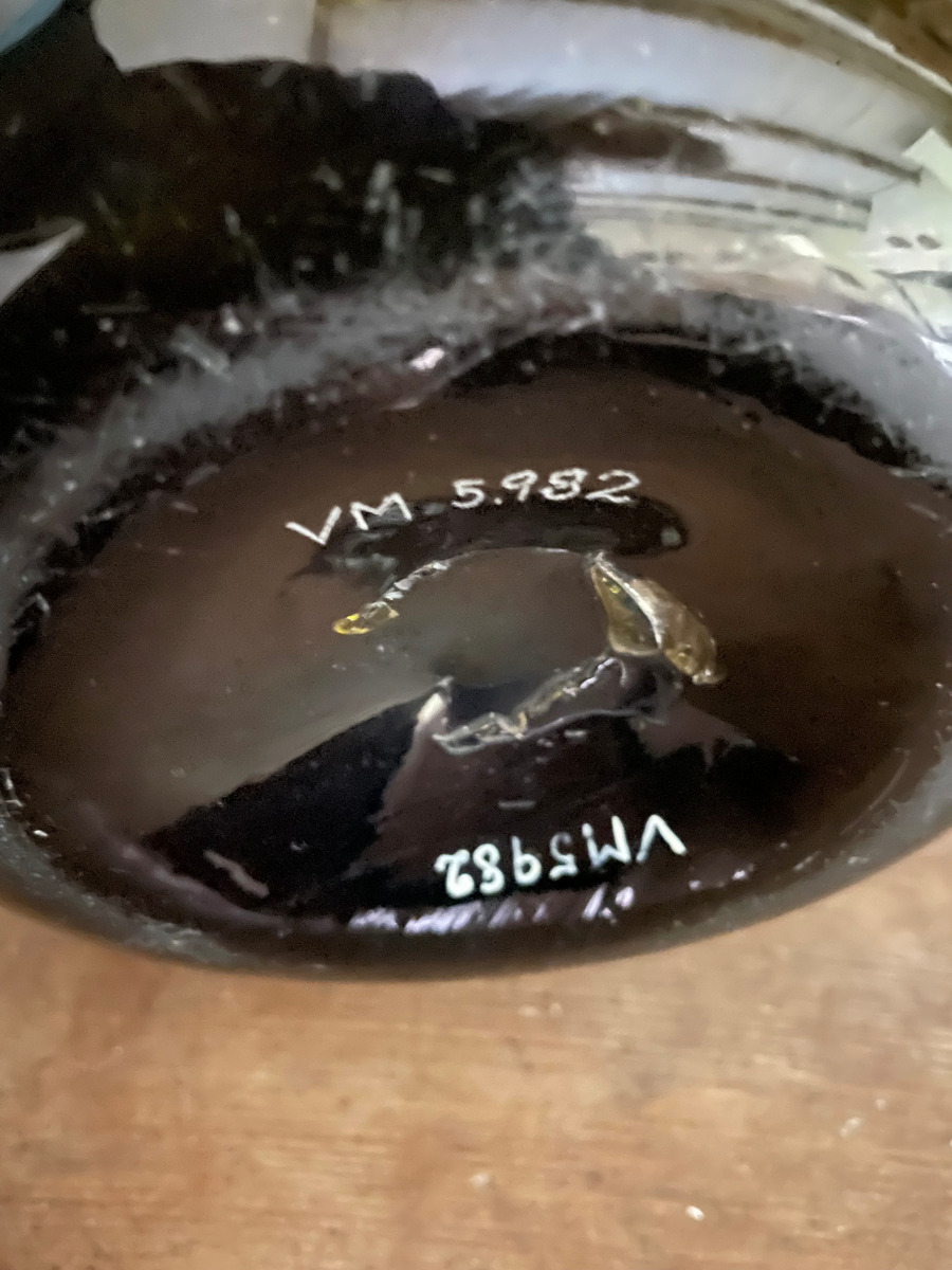 Flaska pôttepôtt av grönt glas, klotformad tillplattad bål och kort hals.