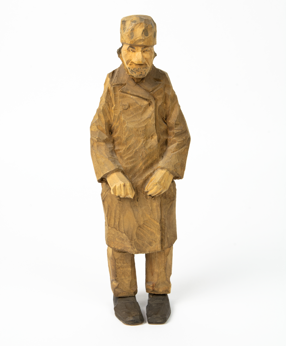 Auktion, skulpturgrupp föreställande sex personer som lyssnar till en auktionist. 
Figurer:
1. Man med händerna i fickorna, randig rock och rutiga byxor, pälsmössa. H 282 mm. 
2. Man med rock och pälsmössa. H 283 mm. 
3. Man med hatt och rock. I handen håller han ett par stövlar, H 274 mm. 
4. Kvinna insvept i schal. Hon håller ett klädesplagg, l 268 mm. 
5. Kvinna med schal och lång kjol. Hon håller ett klädesplagg, H 264 mm.
6. Kvinna insvept i schal.
7. Auktionist, "Ropar-Olle", som håller upp en potta. Den andra handen håller en klubba. Han står på en upp och nedvänd tunna.