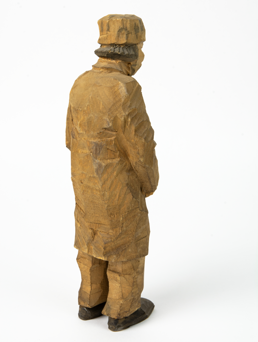 Auktion, skulpturgrupp föreställande sex personer som lyssnar till en auktionist. 
Figurer:
1. Man med händerna i fickorna, randig rock och rutiga byxor, pälsmössa. H 282 mm. 
2. Man med rock och pälsmössa. H 283 mm. 
3. Man med hatt och rock. I handen håller han ett par stövlar, H 274 mm. 
4. Kvinna insvept i schal. Hon håller ett klädesplagg, l 268 mm. 
5. Kvinna med schal och lång kjol. Hon håller ett klädesplagg, H 264 mm.
6. Kvinna insvept i schal.
7. Auktionist, "Ropar-Olle", som håller upp en potta. Den andra handen håller en klubba. Han står på en upp och nedvänd tunna.
