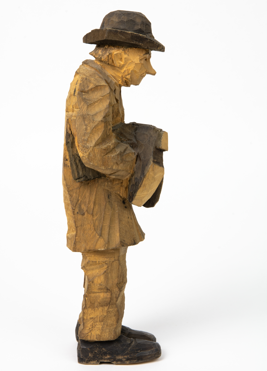 Auktion, skulpturgrupp föreställande sex personer som lyssnar till en auktionist. 
Figurer:
1. Man med händerna i fickorna, randig rock och rutiga byxor, pälsmössa. H 282 mm. 
2. Man med rock och pälsmössa. H 283 mm. 
3. Man med hatt och rock. I handen håller han ett par stövlar, H 274 mm. 
4. Kvinna insvept i schal. Hon håller ett klädesplagg, l 268 mm. 
5. Kvinna med schal och lång kjol. Hon håller ett klädesplagg, H 264 mm.
6. Kvinna insvept i schal.
7. Auktionist, "Ropar-Olle", som håller upp en potta. Den andra handen håller en klubba. Han står på en upp och nedvänd tunna.