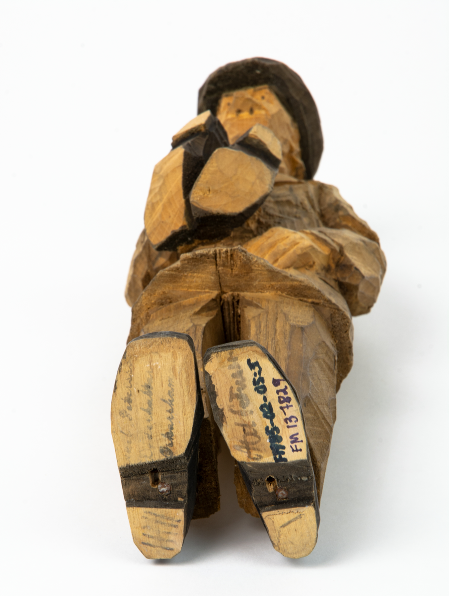 Auktion, skulpturgrupp föreställande sex personer som lyssnar till en auktionist. 
Figurer:
1. Man med händerna i fickorna, randig rock och rutiga byxor, pälsmössa. H 282 mm. 
2. Man med rock och pälsmössa. H 283 mm. 
3. Man med hatt och rock. I handen håller han ett par stövlar, H 274 mm. 
4. Kvinna insvept i schal. Hon håller ett klädesplagg, l 268 mm. 
5. Kvinna med schal och lång kjol. Hon håller ett klädesplagg, H 264 mm.
6. Kvinna insvept i schal.
7. Auktionist, "Ropar-Olle", som håller upp en potta. Den andra handen håller en klubba. Han står på en upp och nedvänd tunna.