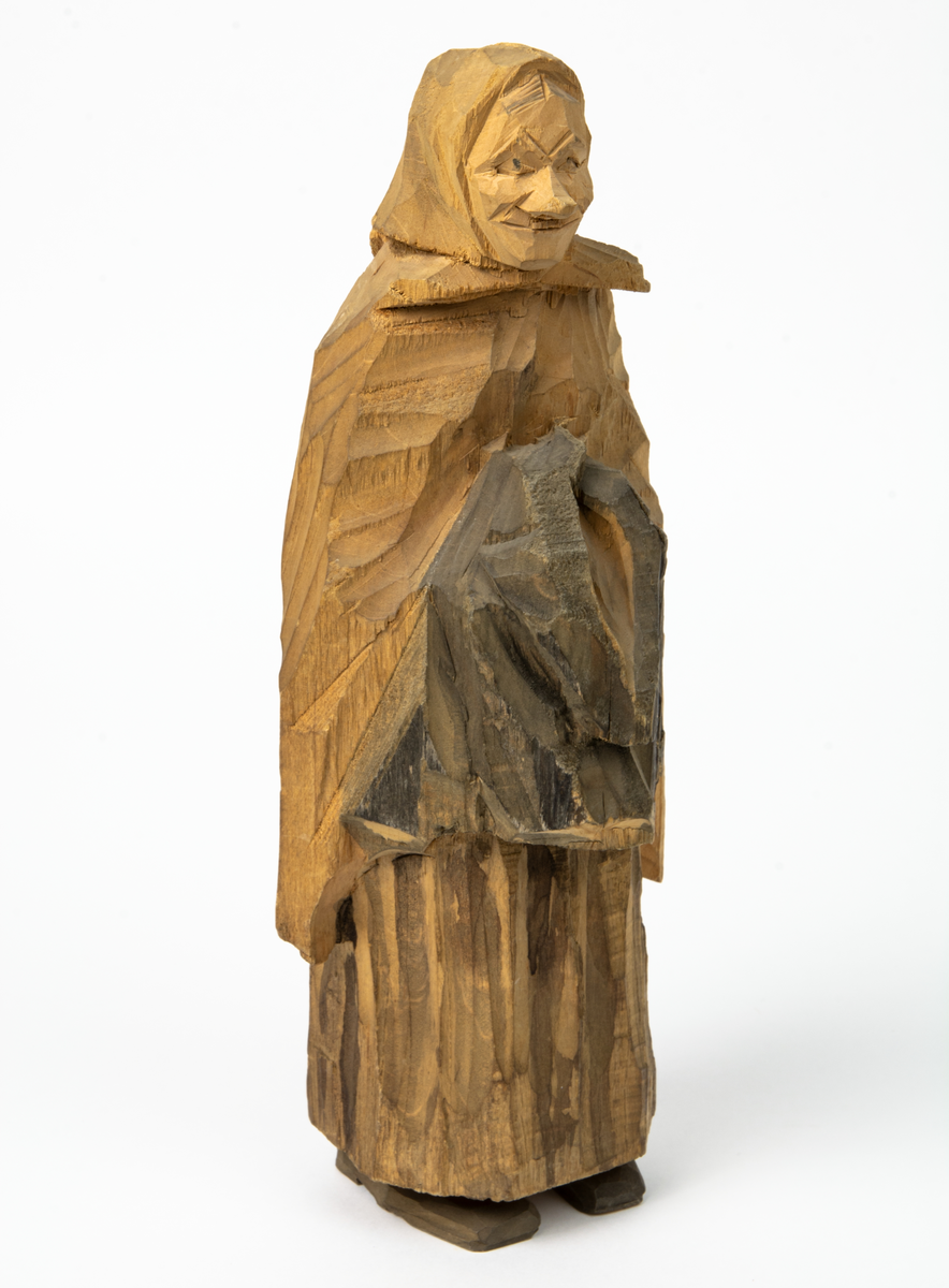 Auktion, skulpturgrupp föreställande sex personer som lyssnar till en auktionist. 
Figurer:
1. Man med händerna i fickorna, randig rock och rutiga byxor, pälsmössa. H 282 mm. 
2. Man med rock och pälsmössa. H 283 mm. 
3. Man med hatt och rock. I handen håller han ett par stövlar, H 274 mm. 
4. Kvinna insvept i schal. Hon håller ett klädesplagg, l 268 mm. 
5. Kvinna med schal och lång kjol. Hon håller ett klädesplagg, H 264 mm.
6. Kvinna insvept i schal.
7. Auktionist, "Ropar-Olle", som håller upp en potta. Den andra handen håller en klubba. Han står på en upp och nedvänd tunna.