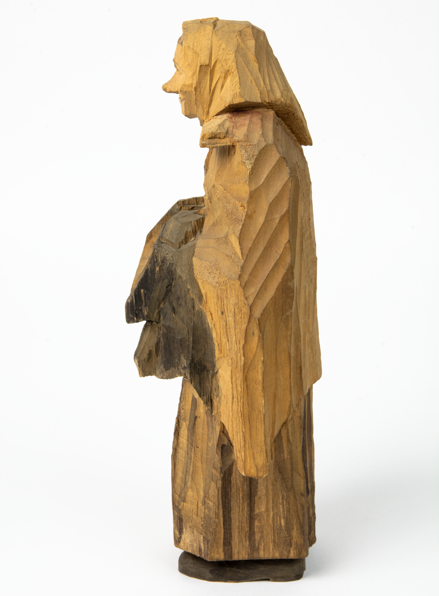 Auktion, skulpturgrupp föreställande sex personer som lyssnar till en auktionist. 
Figurer:
1. Man med händerna i fickorna, randig rock och rutiga byxor, pälsmössa. H 282 mm. 
2. Man med rock och pälsmössa. H 283 mm. 
3. Man med hatt och rock. I handen håller han ett par stövlar, H 274 mm. 
4. Kvinna insvept i schal. Hon håller ett klädesplagg, l 268 mm. 
5. Kvinna med schal och lång kjol. Hon håller ett klädesplagg, H 264 mm.
6. Kvinna insvept i schal.
7. Auktionist, "Ropar-Olle", som håller upp en potta. Den andra handen håller en klubba. Han står på en upp och nedvänd tunna.