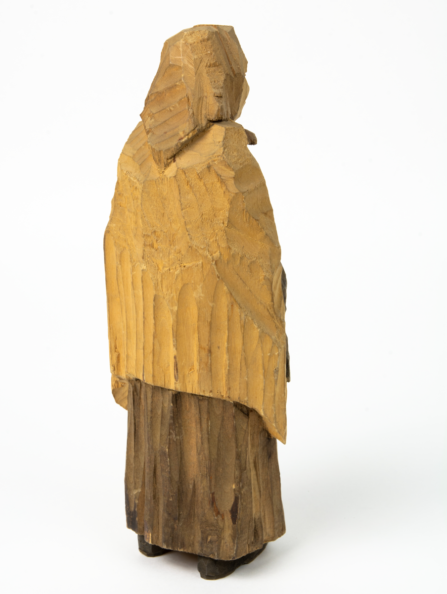 Auktion, skulpturgrupp föreställande sex personer som lyssnar till en auktionist. 
Figurer:
1. Man med händerna i fickorna, randig rock och rutiga byxor, pälsmössa. H 282 mm. 
2. Man med rock och pälsmössa. H 283 mm. 
3. Man med hatt och rock. I handen håller han ett par stövlar, H 274 mm. 
4. Kvinna insvept i schal. Hon håller ett klädesplagg, l 268 mm. 
5. Kvinna med schal och lång kjol. Hon håller ett klädesplagg, H 264 mm.
6. Kvinna insvept i schal.
7. Auktionist, "Ropar-Olle", som håller upp en potta. Den andra handen håller en klubba. Han står på en upp och nedvänd tunna.