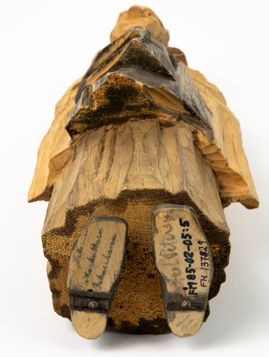 Auktion, skulpturgrupp föreställande sex personer som lyssnar till en auktionist. 
Figurer:
1. Man med händerna i fickorna, randig rock och rutiga byxor, pälsmössa. H 282 mm. 
2. Man med rock och pälsmössa. H 283 mm. 
3. Man med hatt och rock. I handen håller han ett par stövlar, H 274 mm. 
4. Kvinna insvept i schal. Hon håller ett klädesplagg, l 268 mm. 
5. Kvinna med schal och lång kjol. Hon håller ett klädesplagg, H 264 mm.
6. Kvinna insvept i schal.
7. Auktionist, "Ropar-Olle", som håller upp en potta. Den andra handen håller en klubba. Han står på en upp och nedvänd tunna.