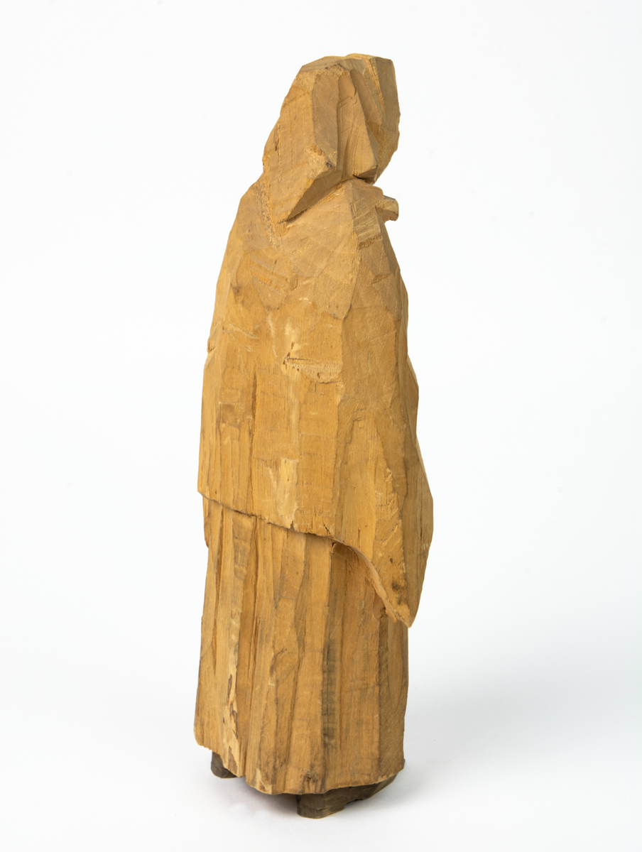 Auktion, skulpturgrupp föreställande sex personer som lyssnar till en auktionist. 
Figurer:
1. Man med händerna i fickorna, randig rock och rutiga byxor, pälsmössa. H 282 mm. 
2. Man med rock och pälsmössa. H 283 mm. 
3. Man med hatt och rock. I handen håller han ett par stövlar, H 274 mm. 
4. Kvinna insvept i schal. Hon håller ett klädesplagg, l 268 mm. 
5. Kvinna med schal och lång kjol. Hon håller ett klädesplagg, H 264 mm.
6. Kvinna insvept i schal.
7. Auktionist, "Ropar-Olle", som håller upp en potta. Den andra handen håller en klubba. Han står på en upp och nedvänd tunna.